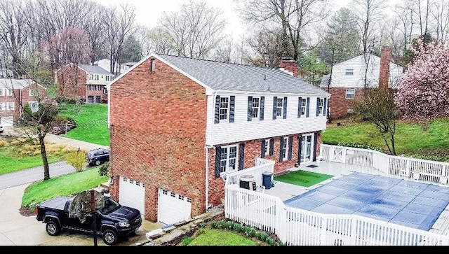 112 Carol Dr, Peters Twp, PA 15317 - rear view of house with brick siding, an attached garage, a chimney, and a lawn