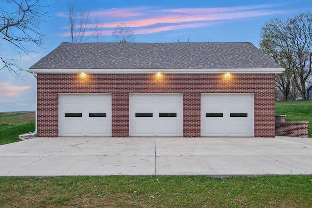 garage at dusk featuring a detached garage