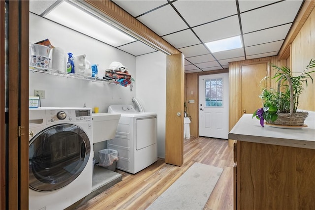 laundry area featuring light wood-type flooring and separate washer and dryer