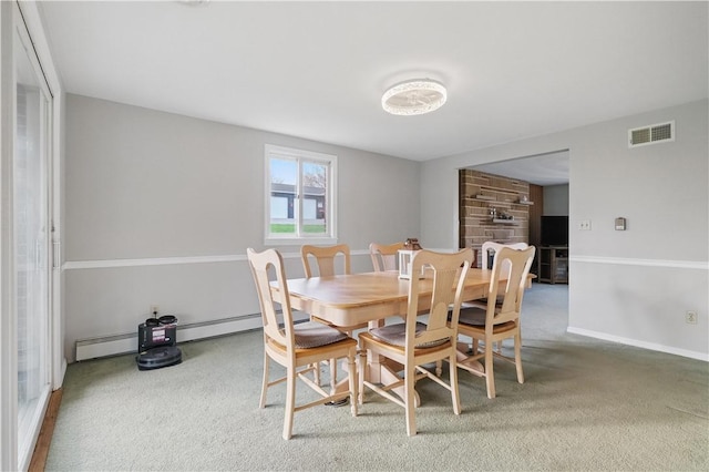 dining room with a baseboard heating unit, carpet flooring, visible vents, and baseboards