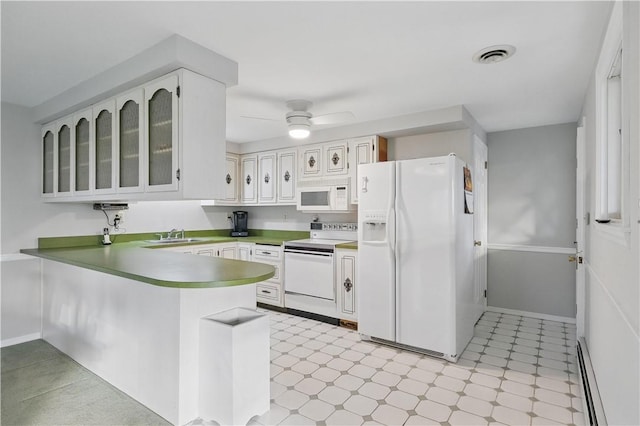 kitchen featuring visible vents, white appliances, a peninsula, a baseboard heating unit, and light floors