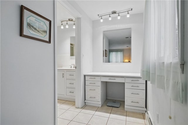 bathroom with track lighting, tile patterned flooring, a baseboard heating unit, and vanity