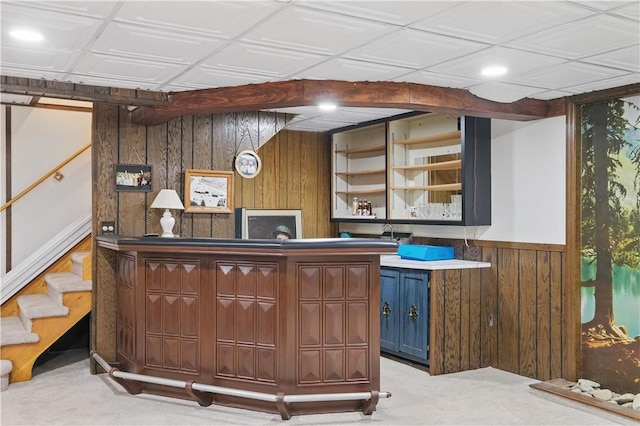 bar with wood walls, stairway, and light carpet