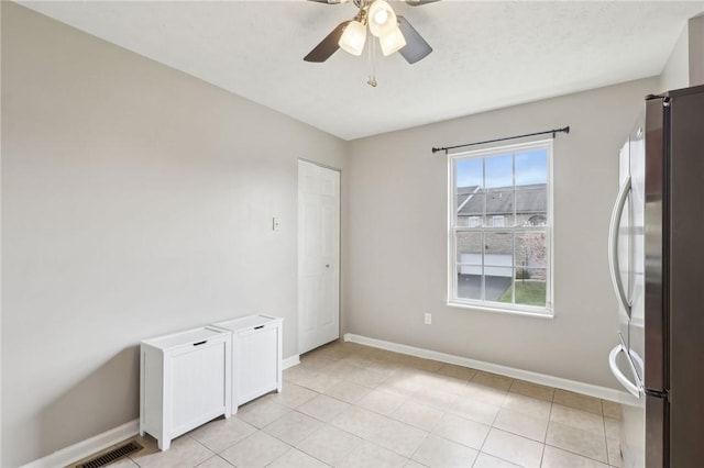 unfurnished room featuring ceiling fan, baseboards, and visible vents