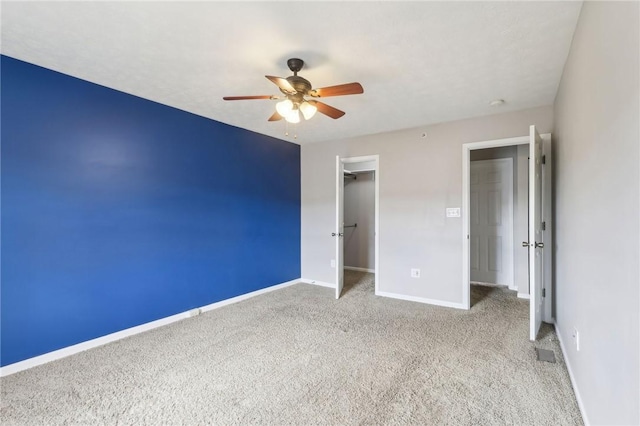 unfurnished bedroom featuring a closet, light colored carpet, a ceiling fan, visible vents, and baseboards