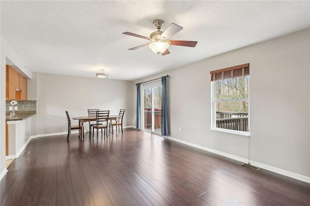 dining room with visible vents, ceiling fan, baseboards, and dark wood-style floors