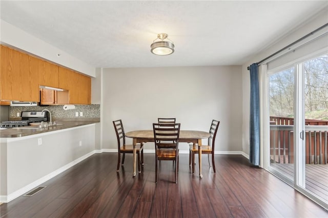 dining area featuring dark wood-style floors, baseboards, and visible vents