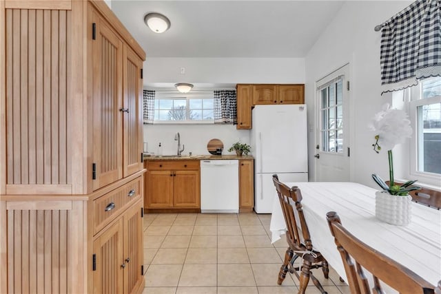 kitchen featuring light tile patterned floors, a sink, white appliances, and plenty of natural light
