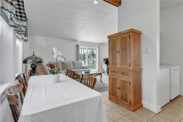 dining room featuring light tile patterned floors, washer and clothes dryer, and baseboards