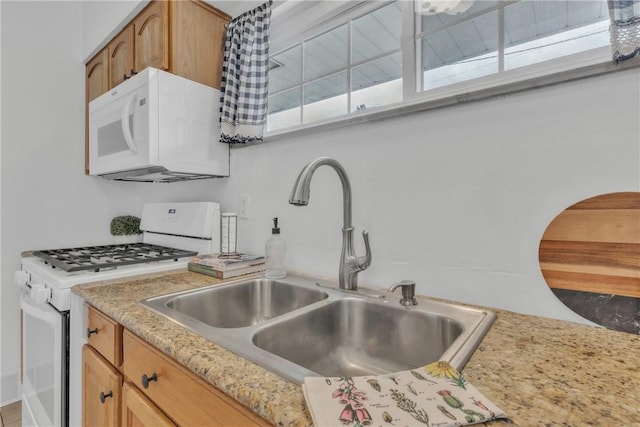kitchen featuring white appliances and a sink