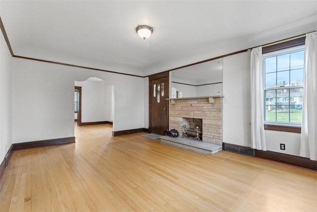 40 Terrace Rd, East Bethlehem, PA 15348 - unfurnished living room featuring baseboards, arched walkways, a stone fireplace, crown molding, and hardwood / wood-style floors