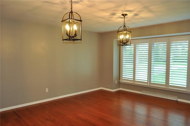 spare room with baseboards, a notable chandelier, and dark wood-style floors