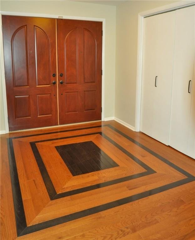foyer entrance with baseboards and wood finished floors