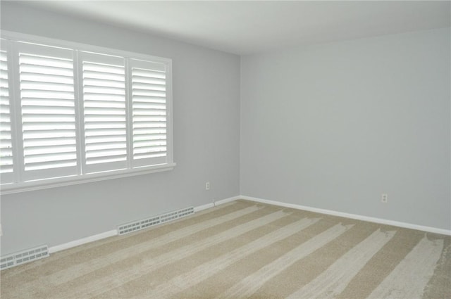 unfurnished room featuring baseboards, carpet, and visible vents