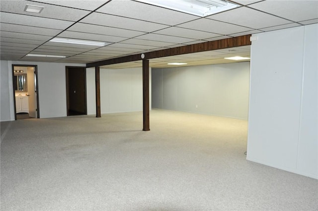 finished basement with carpet and a paneled ceiling