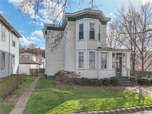 view of front of home featuring fence and a front lawn