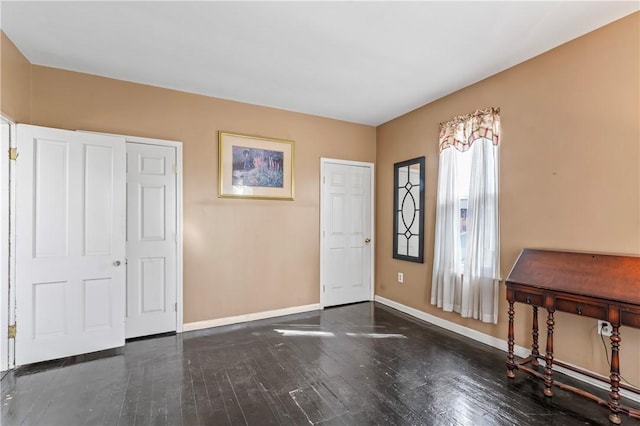 foyer with baseboards and hardwood / wood-style floors
