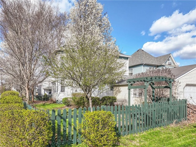 view of front of property featuring fence and a garage