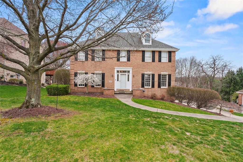 view of front of property with a front lawn and brick siding
