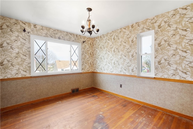 3555 Middleboro Rd, Castle Shannon, PA 15234 - empty room featuring wallpapered walls, an inviting chandelier, visible vents, and hardwood / wood-style flooring