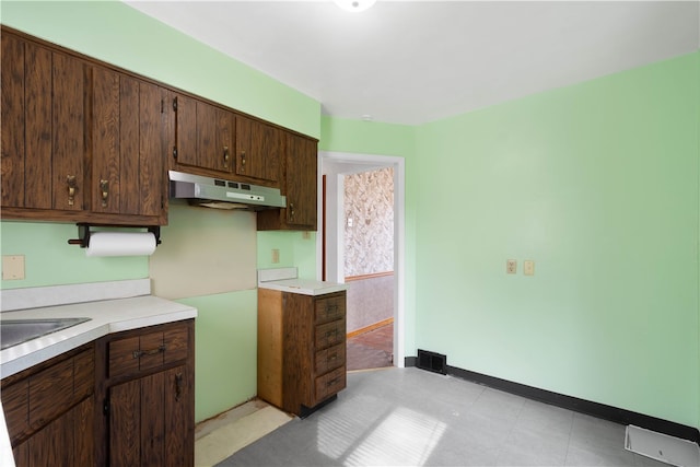 3555 Middleboro Rd, Castle Shannon, PA 15234 - kitchen with under cabinet range hood, light countertops, baseboards, and dark brown cabinets