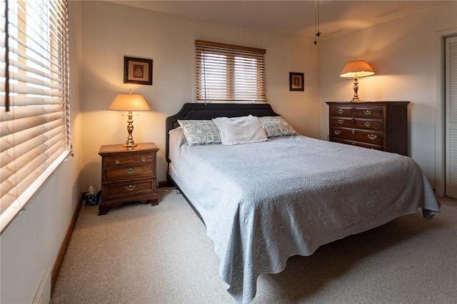 bedroom with baseboards and light colored carpet