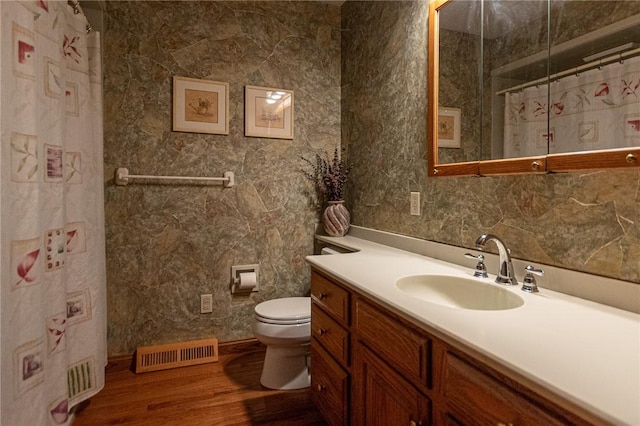 full bathroom with vanity, a shower with curtain, toilet, visible vents, and wood finished floors