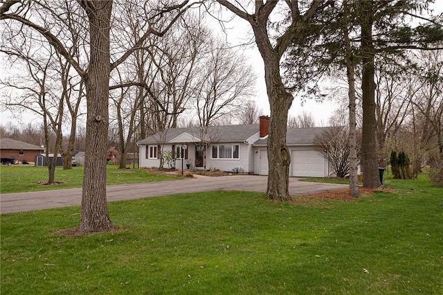 ranch-style home with a chimney, driveway, a front yard, and a garage