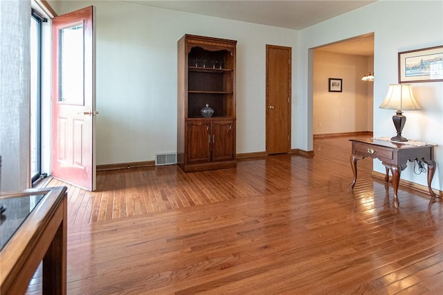 living room with visible vents, baseboards, and light wood-type flooring