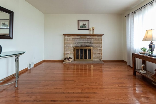 living area with visible vents, baseboards, and wood finished floors