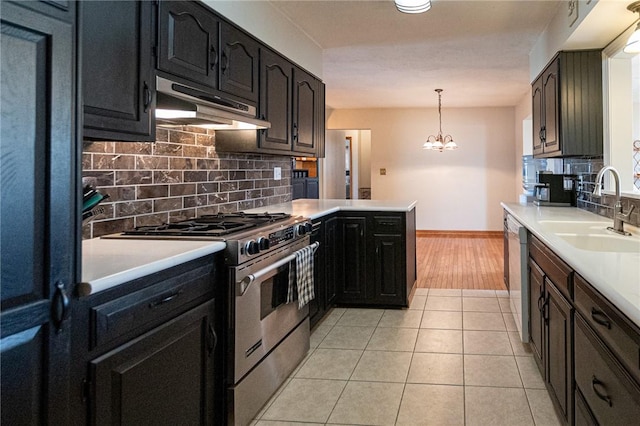 kitchen featuring light tile patterned floors, dishwasher, under cabinet range hood, stainless steel gas stove, and a sink
