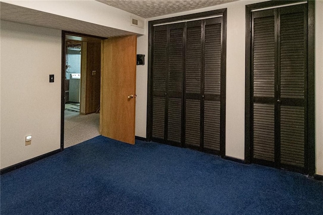 unfurnished bedroom with a textured ceiling, carpet flooring, and baseboards