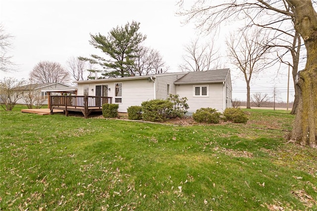 back of house with a deck and a lawn