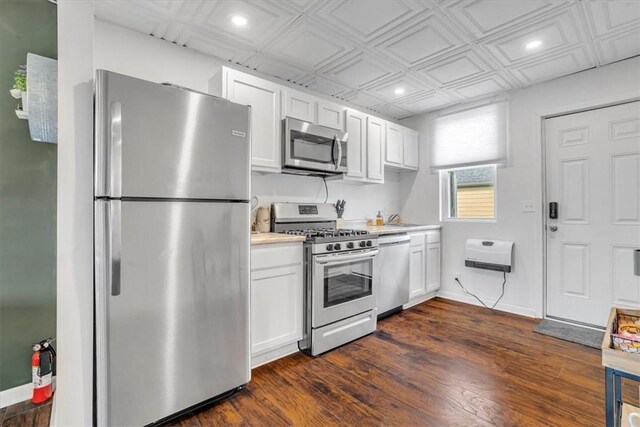 329 Downing St, Polish Hill, PA 15219 - kitchen featuring white cabinets, light countertops, appliances with stainless steel finishes, dark wood-style floors, and an ornate ceiling