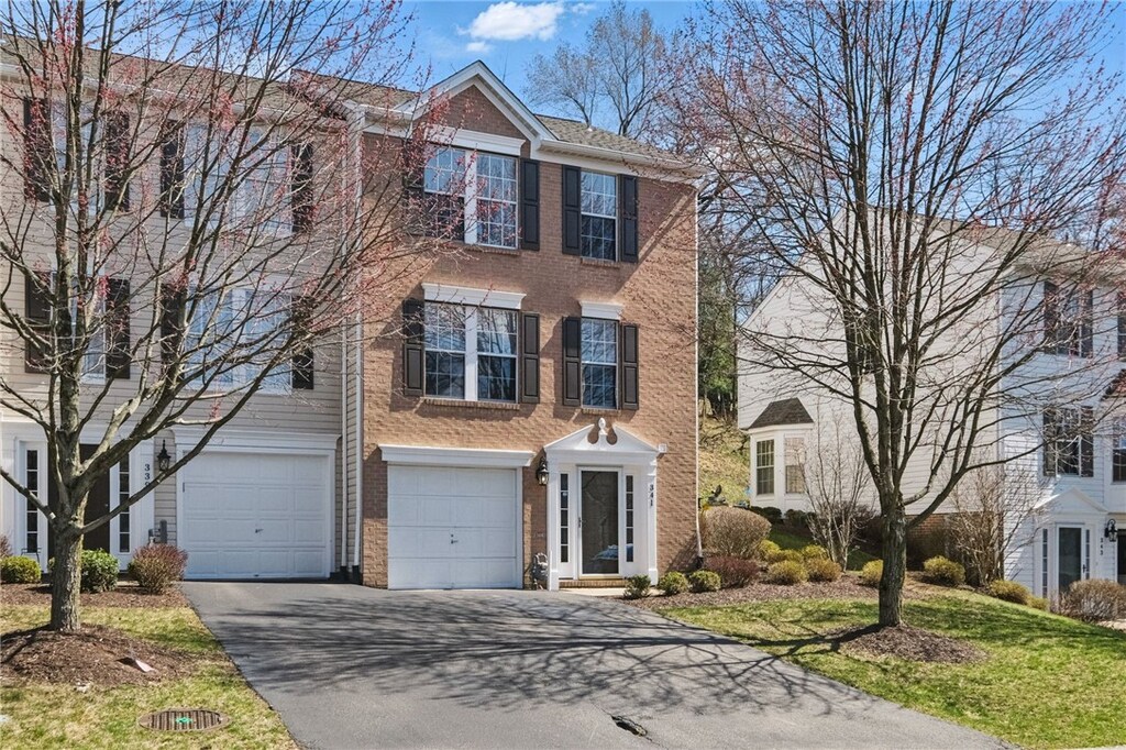 341 Murrays Ln, Castle Shannon, PA 15234 - view of front facade with brick siding, a garage, and aphalt driveway
