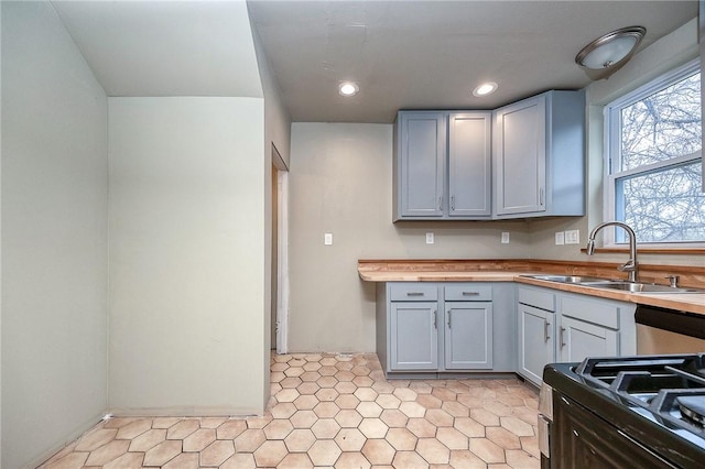 kitchen featuring stainless steel dishwasher, recessed lighting, gas stove, a sink, and gray cabinetry