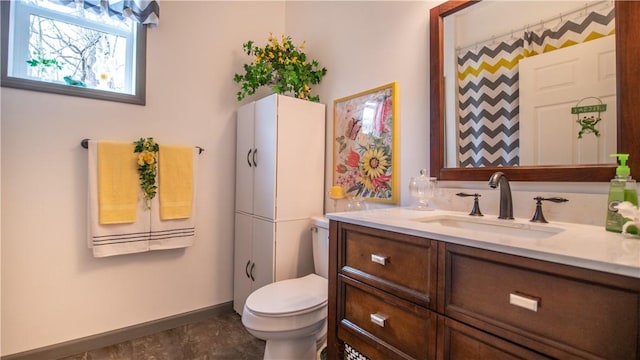 full bathroom with vanity, toilet, and baseboards