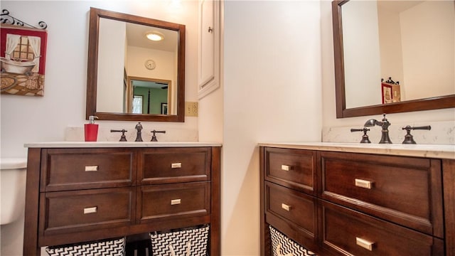 bathroom with two vanities and toilet