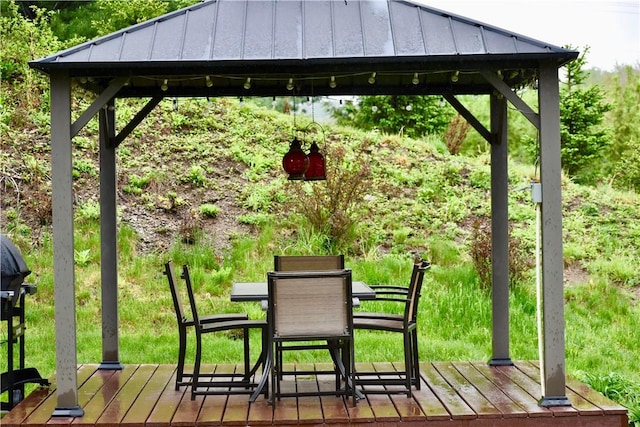 deck with outdoor dining area and a gazebo
