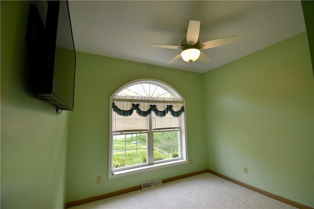carpeted spare room with baseboards and ceiling fan