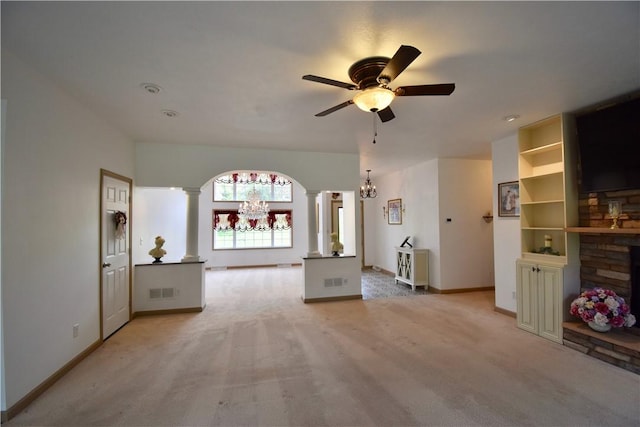 unfurnished living room with ornate columns, a chandelier, light colored carpet, ceiling fan, and baseboards