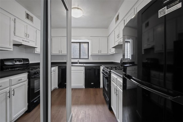 kitchen featuring dark countertops, visible vents, black appliances, and under cabinet range hood