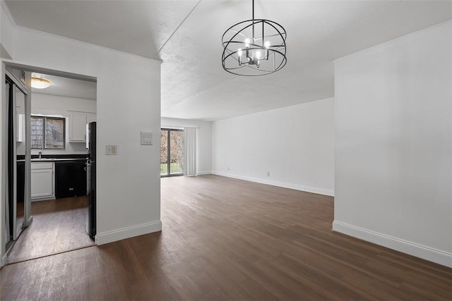 unfurnished dining area featuring baseboards, an inviting chandelier, and dark wood finished floors