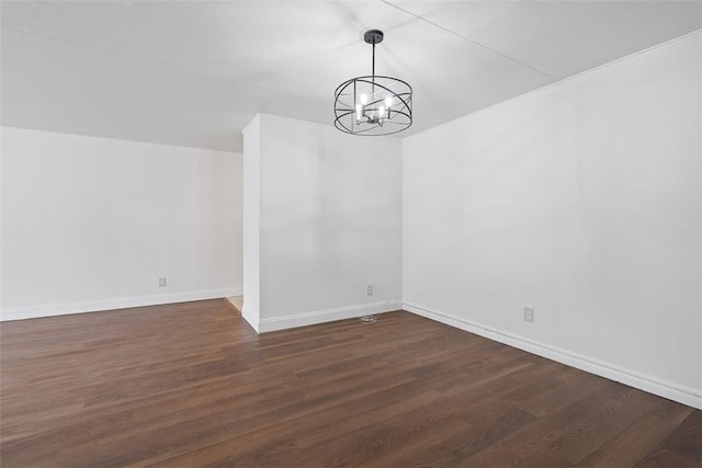unfurnished dining area with dark wood-type flooring, baseboards, and a chandelier
