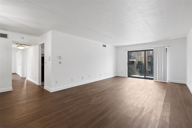 unfurnished living room featuring dark wood-style floors, baseboards, visible vents, and a textured ceiling