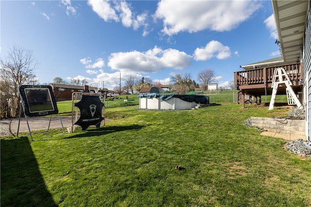 view of yard featuring a deck and a covered pool