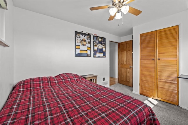 carpeted bedroom with a closet, ceiling fan, and visible vents
