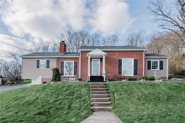 view of front facade featuring brick siding, a chimney, and a front lawn