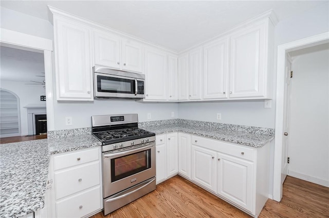 kitchen featuring stainless steel appliances, light wood finished floors, and white cabinetry