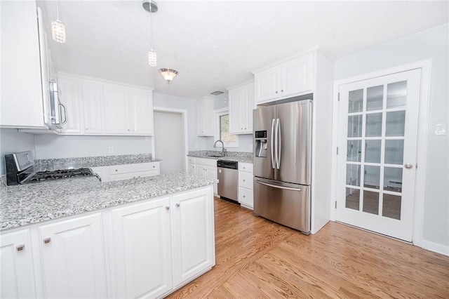 kitchen featuring a sink, light wood-type flooring, appliances with stainless steel finishes, and white cabinetry